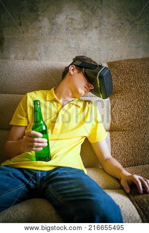Young Man in VR Glasses with a Beer sleep on the Sofa