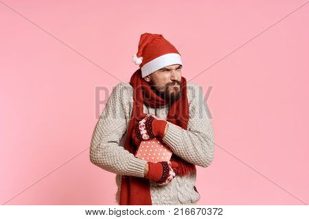 man holds a gift, light pink background, free space for copying, new year.