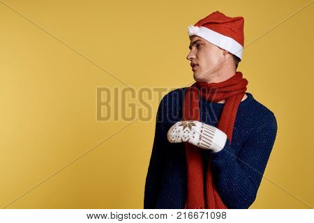 man in mittens on a light yellow background, free space for copying, new year.