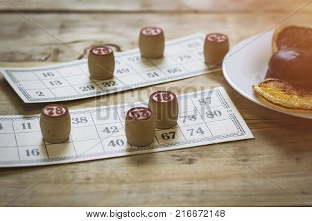 Cards And Chips For Playing Bingo On A Wooden Table. Cup With Coffee