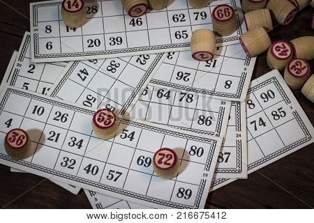 On A Wooden Bingo Table Game, A Cup With A Coffee, A Biscuit And An Orange Slice