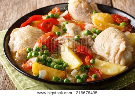 Pieces Of Chicken Stew With Potatoes, Peppers, Tomatoes, Peas And Onions Close-up. Vertical Top View