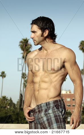Portrait du corps dans la lumière naturelle d'un beau mannequin occasionnel du torse nu à la recherche hors
