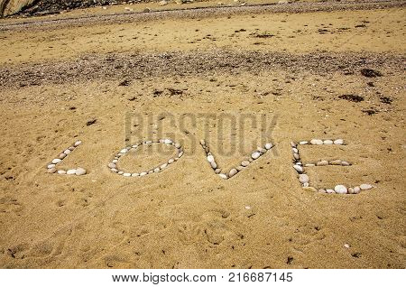 beach of myrtos and inscription in it with white stones of the word love