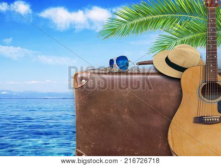 Concept of summer traveling with old suitcase and guitar