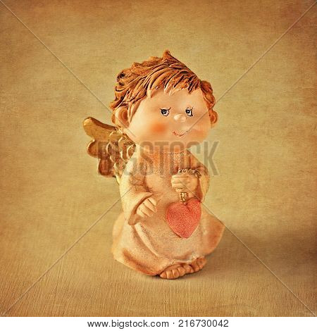 Angel toy with a heart in hand .Christmas card. Christmas decoration.