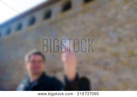 A blurred and abstract image of how a man does a salf on the background of an old fortress.