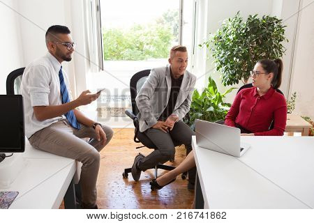 Pensive startuppers brainstorming in small office. Amazed businesswoman shocked with colleagues news. Office friends talking during break. Office lifestyle concept