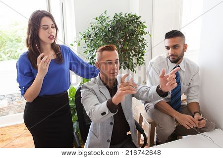 Team leader gesturing while explaining his idea to colleagues at staff meeting. Pensive coworkers thinking of new project. Business visualization concept