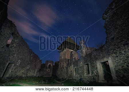 Ruins of Nevitsky Castle near Uzhgorod, Ukraine with a lot of shiny stars on the dark blue sky