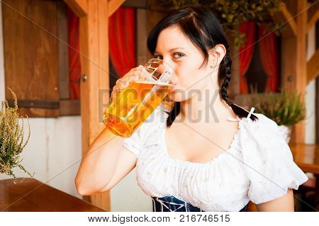 young german woman enjoying a mug of beer