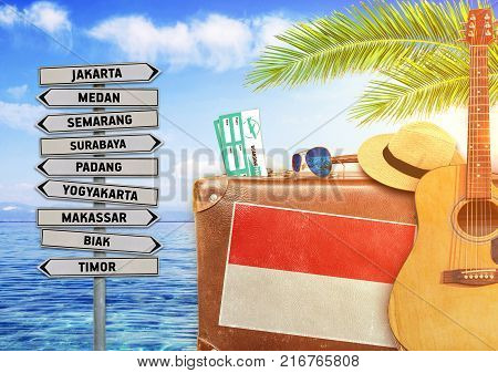 Concept of summer traveling with old suitcase and Indonesia town sign