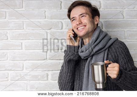 Portrait of a Modern Young Man with a Phone and a Mug