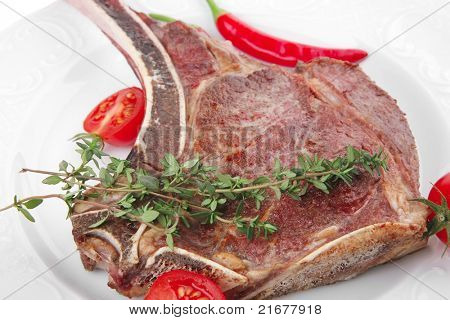 cibo di carne: manzo alla griglia di ricambio rib su piatto bianco con timo pepe e pomodoro isolato sopra bianca ba