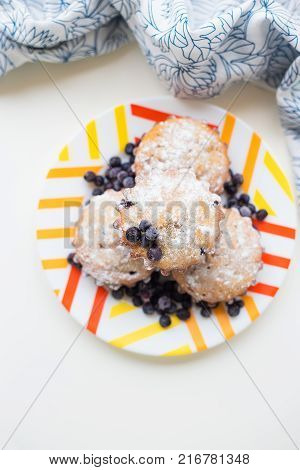 Blueberry muffins on plate and bright floral cloth