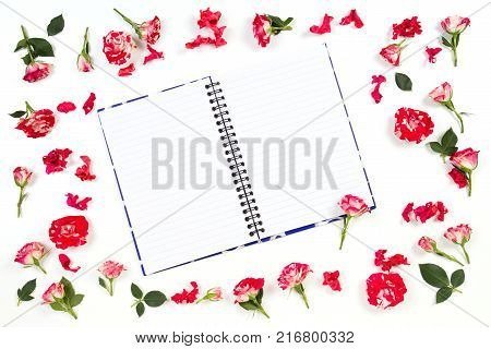 Flowers composition. Frame made of rose flowers. Open paper notebook or diary in the middle. Flat lay, top view