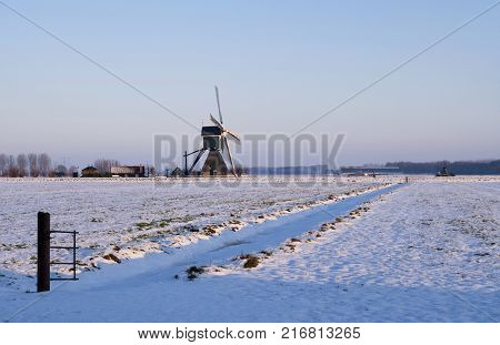 Windmill the Wingerdse Molen in a snow covered landscape near the Dutch village Bleskensgraaf