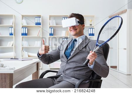 Businessman playing virtual reality tennis in office with VR gog