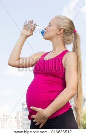 The Pregnant Woman Drinks Water. Sports Concept