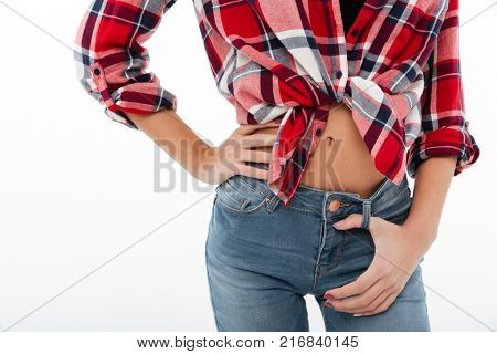Close up portrait of a slim woman dressed in plaid shirt and jeans posing isolated over white background