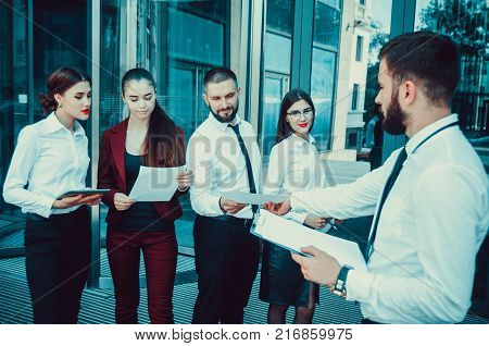 Business. Office Staff. Five Young Managers With Electronic Tablets Communicate Against The Backgrou