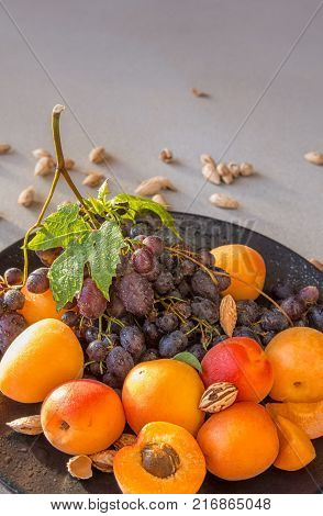 Fruit plate with grapes, apricot and almond on gray. Helthy food backround. Poster, magazine cover