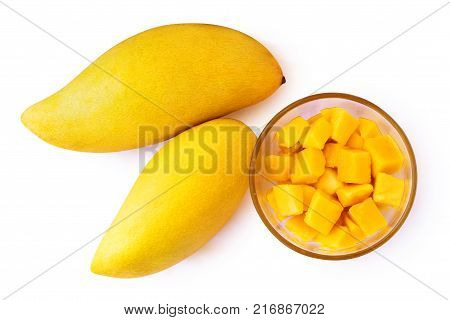 Two mango fruits and mango cubes on a plate. Isolated on white background