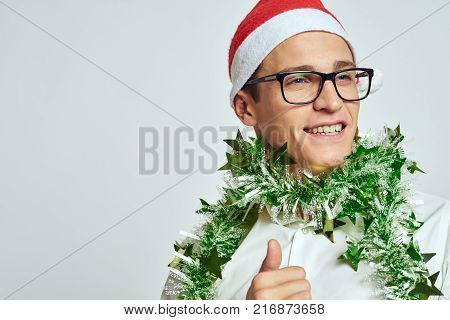 man in glasses and green tinsel around his neck, portrait, new year, bright background, free space for copying.