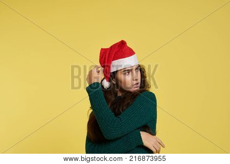 woman in a green dress on a light yellow background, free space for copy, new year, holiday.