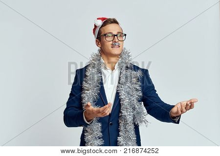 man in a jacket, tinsel, artificial mustache, light background, holiday, new year.