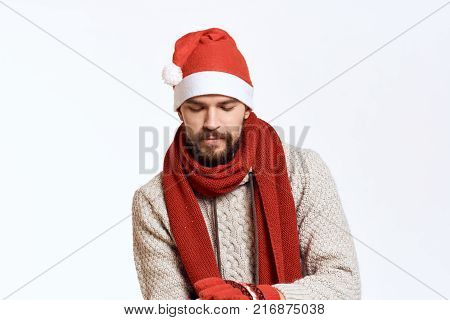 man in a New Year hat and scarf looks down, white background, holiday, new year.