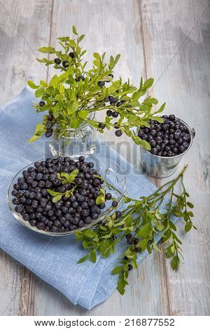 Fresh forest berry, blueberries in a glass plate on a wooden table.