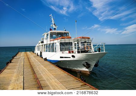 A pleasure boat moored to the pier. Walks by the sea.
