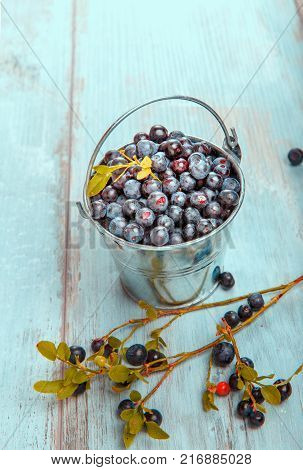 Fresh forest berry, blueberries in a glass plate on a wooden table.