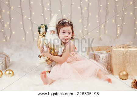 Portrait of white Caucasian children friends siblings celebrating Christmas or New Year. Little cute adorable girl and boy in studio with winter holiday decoration