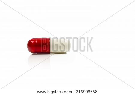 Red white antibiotics capsule pill isolated on white background with copy space. Drug resistance concept. Antibiotics drug use with reasonable and global healthcare concept.