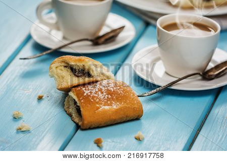 Traditional czech buns with plum jam and coffee on blue wood table