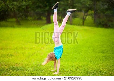 Active Little School Girl Somersault Outdoors.