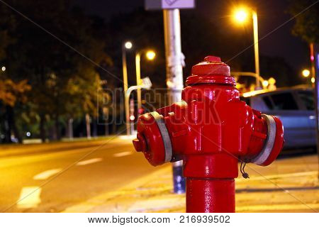 lonely red fire hydrant in the middle of a night street near the road concept. Fire hydrant for emergency fire access.
