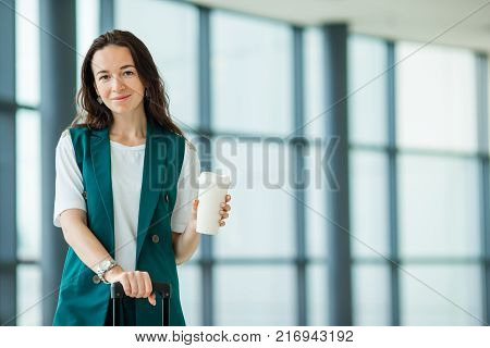 Young woman in international airport walking with her luggage.