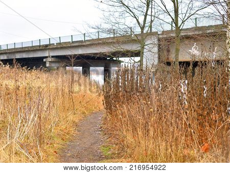 Road in park at autumn and old bridge at cloud day Russia.