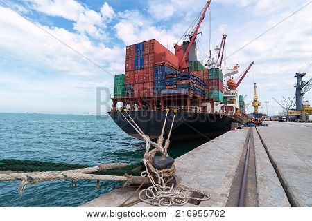 container ship commercial vessel alongside in port for loading and discharging containers services in maritime transports in World wide logistics