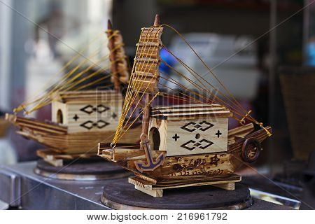 Two small handmade wooden ships in street shop