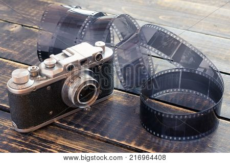 rangefinder film camera and roll on a wooden table
