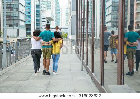 Team Of Male And Female Friends Enjoying Outdoor Walk. Back View Of Mix Raced People Walking Down Ci