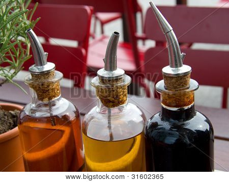 Balsamic Vinegar Bottles And Condiments On The Table In An Open Cafe