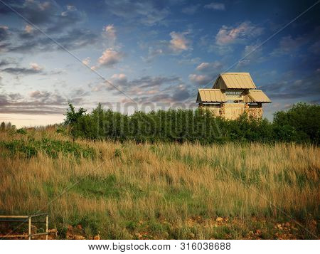Hollow Structure At The Banks Of A Lake, With Beautiful Clouds In The Skies.