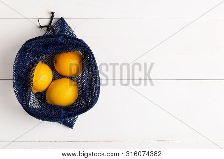 A Reusable Shopping Bag With Lemons On White Background