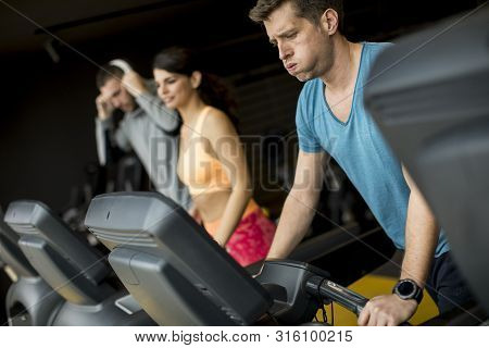 Young People Using Threadmill In Modern Gym