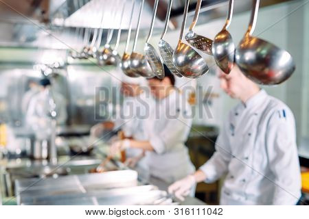 Modern Kitchen. Cooks Prepare Meals On The Stove In The Kitchen Of The Restaurant Or Hotel. The Fire